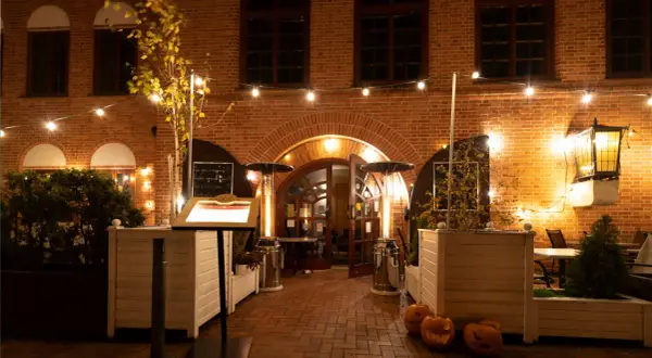 Restauracja Filharmonia zaprasza do swojego przytulnego ogródka. Menu na stojaku, dynie i ciepłe światła tworzą jesienny klimat.