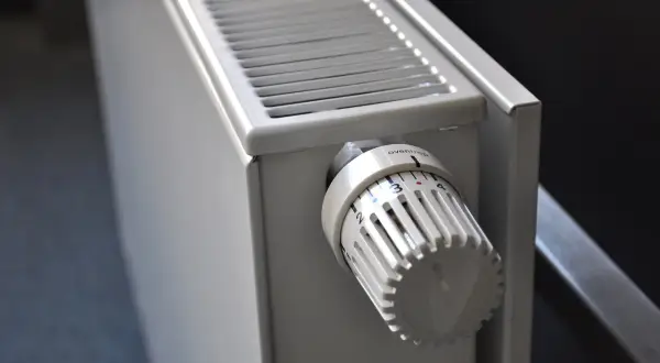 Biały grzejnik z termostatem. Trwa płukanie instalacji co.