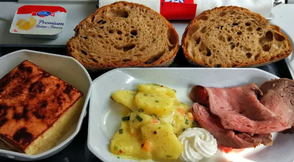 Posiłek w samolocie: pieczywo, pieczeń, ziemniaki w sosie i masło. Smak kuchni szwajcarskiej na wysokości.