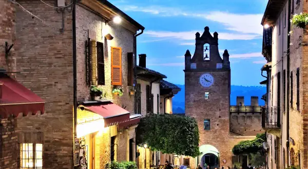 Serata magica a Gradara, Marche. Vicoli illuminati, torre dell'orologio e un'atmosfera incantevole.