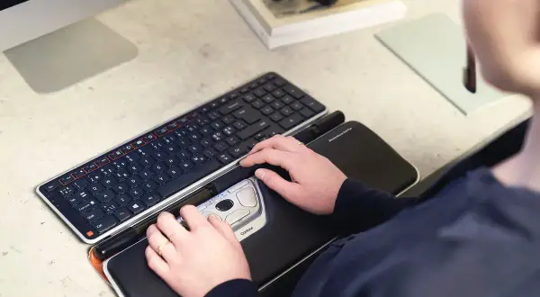 Mains sur un clavier et une souris ergonomique, des pointeurs de souris pour un confort optimal.