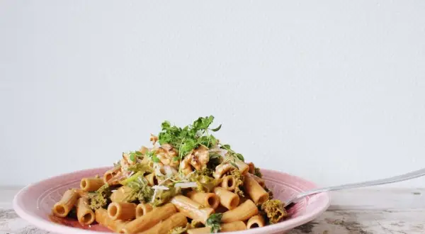 En läcker vegetarisk pasta med broccoli och valnötter, toppad med färska örter.