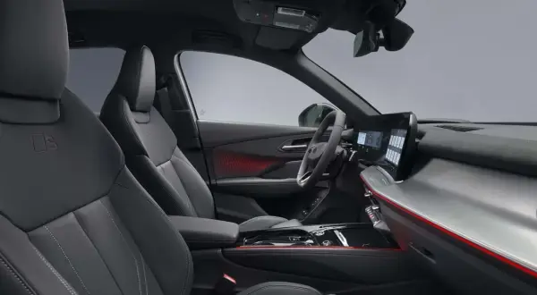 Interni sportivi dell'Audi Q3 Sportback: sedili in pelle nera, illuminazione d'ambiente rossa e un moderno cruscotto digitale.