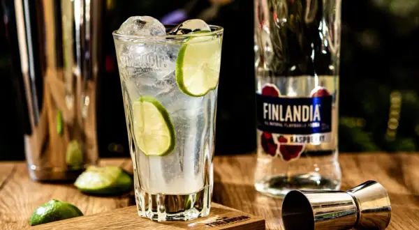 Orzeźwiający drink z lodem i limonką, obok butelka Finlandia Raspberry. Idealny na letnie wieczory.