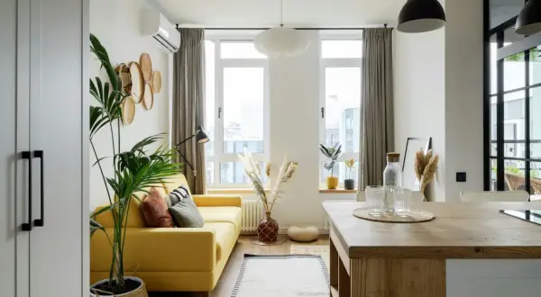 Canapé jaune vif dans un salon lumineux avec des plantes et des paniers décoratifs.