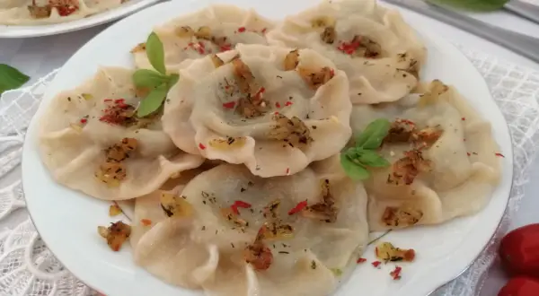Pyszne pierogi ze szpinakiem, posypane skwarkami i ziołami. Idealne z sosem czosnkowym lub kwaśną śmietaną.