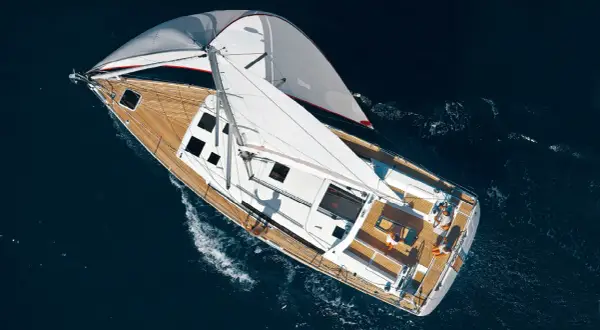 Vela genoa spiegata su un elegante yacht che solca il mare blu.