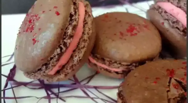 Macarons au chocolat avec ganache framboise et une touche de gélatine pour la brillance.