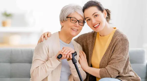 Un modello ap70: due donne sorridono, una anziana con bastone e occhiali, l'altra più giovane con un abbraccio.