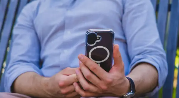 Mężczyzna trzyma telefon, który może wysyłać sygnały haptyczne.