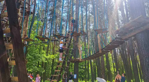 Park linowy w Białymstoku oferuje ekscytujące atrakcje dla dorosłych, w tym mosty wiszące i przeszkody na wysokości.