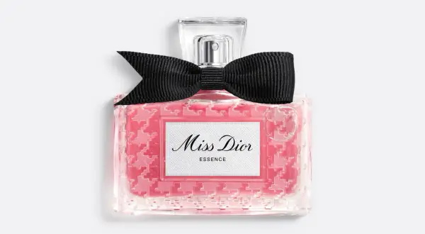 Różowy flakonik Miss Dior Essence z czarną kokardką, pachnący jak soczysta wiśnia.