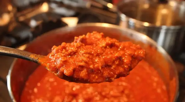 Un cucchiaio di sugo per pasta maritati, denso e saporito, pronto per condire un piatto di pasta fumante.