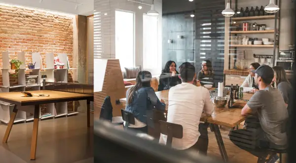 Grupp samlad runt ett bord i ett modernt kontor med tegelvägg. Bra tips för en avslappnad arbetsmiljö.