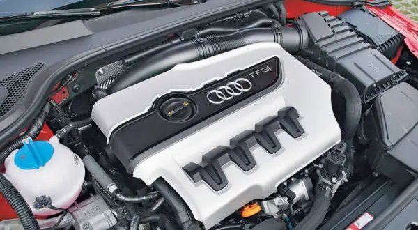 Silnik 2.0 TFSI Audi z charakterystycznymi czterema pierścieniami i osłoną.