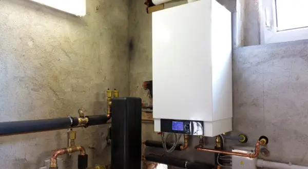 Installazione di una moderna caldaia a condensazione con tubature in rame e isolamento termico.