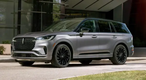 Szary Lincoln Aviator z czarnymi felgami stoi przed nowoczesnym budynkiem.