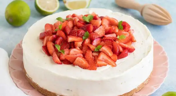 En krämig vit choklad cheesecake toppad med färska jordgubbar och mynta. En perfekt sommardessert!
