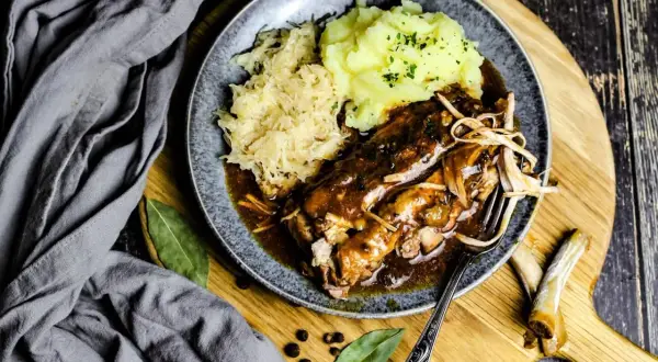 Herzhaftes Gericht mit Rippchen, Sauerkraut und Kartoffelpüree, serviert auf einem Teller. Perfekt für einen gemütlichen Abend.