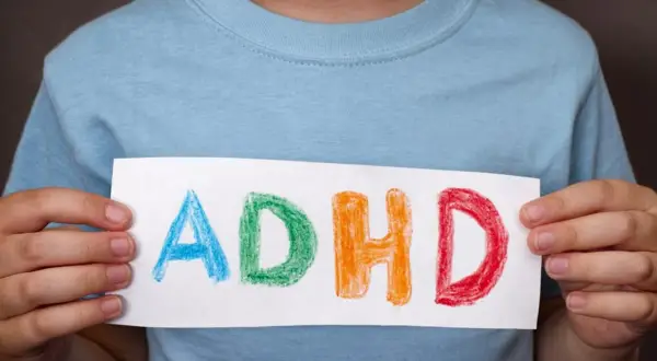 Dziecko trzyma kartkę z napisem ADHD. Czy medikinet ma skutki uboczne?