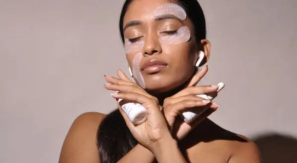 Donna con cerotti per il contorno occhi e creme, per combattere il viso stanco. Rimedi di bellezza per un aspetto radioso.