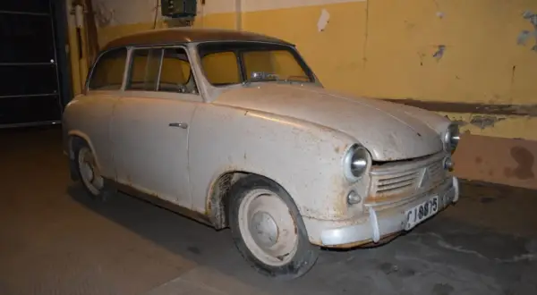 En rostig lloyden bil står i ett garage.