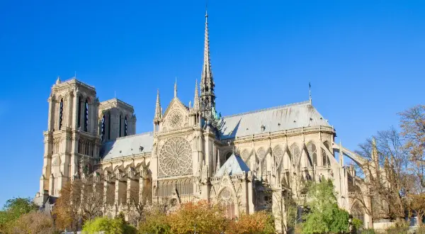 Majestatyczna katedra Notre Dame w Paryżu, idealna na **itaka wycieczka do Paryża samolotem**. Wspaniała architektura i jesienne drzewa.