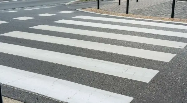 Lignes blanches sur l'asphalte, un passage piéton invite à traverser la rue en toute sécurité.