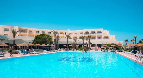 Basen hotelowy Vincci Dar Midoun. Słoneczny dzień, palmy, leżaki i ludzie relaksujący się przy wodzie.