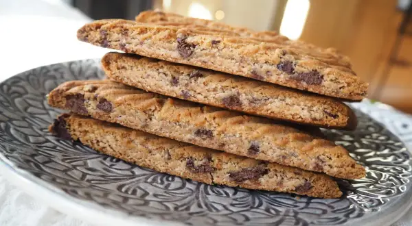 En stapel hembakade kolasnittar med choklad, redo att avnjutas.