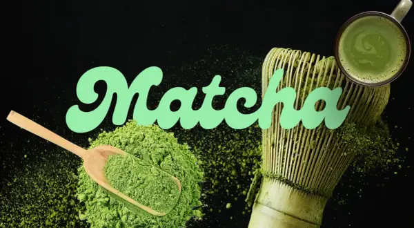 Poudre de matcha verte, cuillère en bois, fouet et tasse de boisson, évoquant le goût matcha authentique.