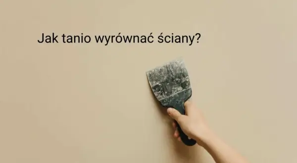 Dłoń trzyma szpachelkę przy lekko nierównej, beżowej ścianie. Jak tanio wyrównać ściany?
