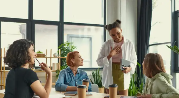 Grupo de mujeres en una reunión discutiendo cómo trabajar la autoestima.