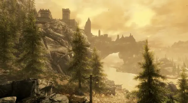 Majestatyczny krajobraz Skyrim z zamkiem na wzgórzu i łukiem skalnym. Idealny do sprawdzenia wymagań sprzętowych gry.