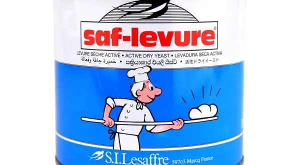 Boîte de levure boulangère déshydratée Saf-Levure, avec un dessin de boulanger souriant.