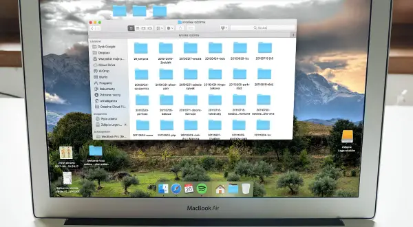 Na ekranie MacBook Air widać okno programu do segregowania zdjęć, z folderami o nazwach dat.