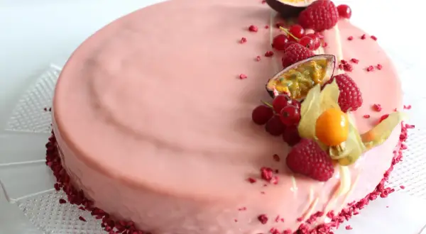 En vacker hallon och passionsfrukt tårta med färska bär och passionsfrukt som dekoration.