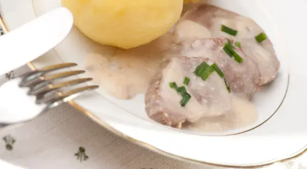 Bamberger Krenfleisch mit Klößen und einer cremigen Soße, garniert mit Schnittlauch. Ein deftiges Gericht.
