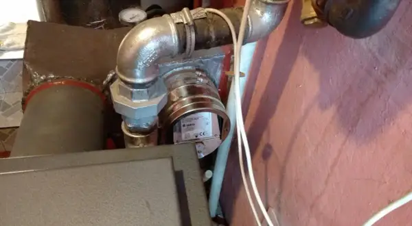 Regulator ciągu kominowego zamontowany na rurze odprowadzającej spaliny z kotła.