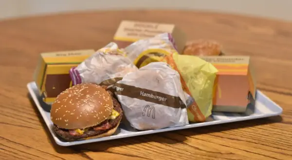 Taca pełna hamburgerów z McDonald's. Widać opakowania Big Mac, McRoyal i inne.