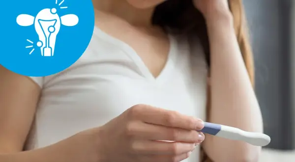 Kobieta z niepokojem patrzy na test ciążowy. Ikona symbolizuje problemy z płodnością, takie jak endometrioza a ciąża.