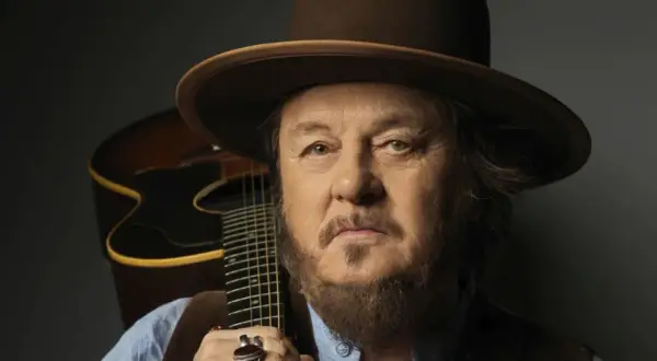 Mężczyzna w kapeluszu z gitarą, uosobienie Dire Straits Legacy.