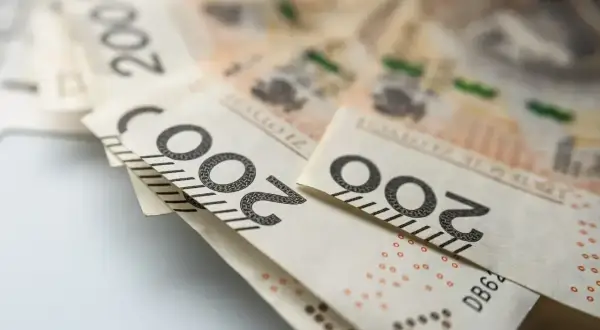 Polskie banknoty 200 zł leżące na jasnym tle.