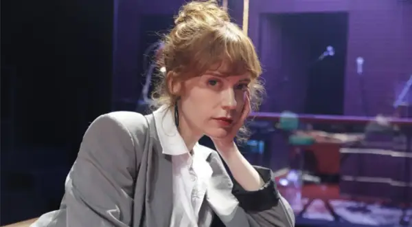 Itsaso Arana, con su cabello recogido y un gesto pensativo, posa con un traje gris sobre una camisa blanca.