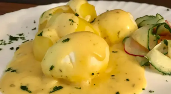 Senfeier rezept: pochiere Eier in cremiger Sauce mit Kartoffeln und einem frischen Gurkensalat.