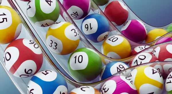 Kolorowe kule lotto wpadają do maszyny. Czy nagroda w loterii pożyczkowej jest zwolniona z podatku od wzbogacenia?