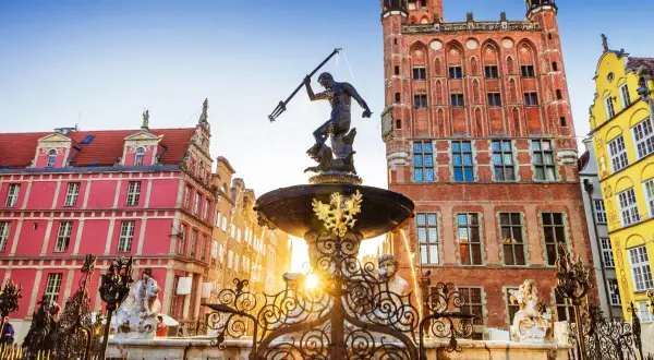 Neptunfontänen i Gamla stan i Gdansk, med sina färgglada hus och ett imponerande tegelhus med klocktorn.