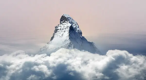 Majestätisches Matterhorn Nordwand ragt aus Wolken empor, ein eisiger Gigant im sanften Licht des Himmels.