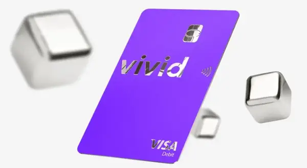 Fioletowa karta płatnicza Vivid Visa Debit, otoczona metalicznymi sześcianami, symbolizuje dostęp do żywych pieniędzy i nowoczesnych płatności.