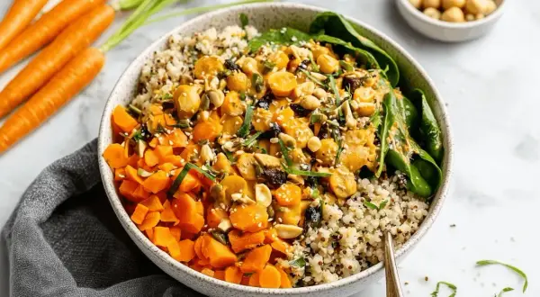 Bunter Quinoa-Bowl mit Karottenwürfeln, Kichererbsen und Nüssen. Ein leckeres Beispiel für Karotten Rezepte.